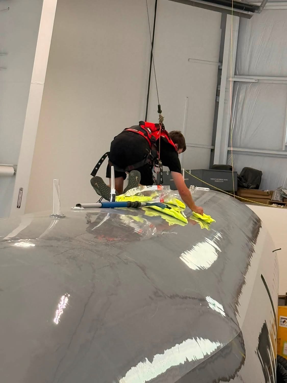 Departure Group technician safely cleaning the top of an executive aircraft